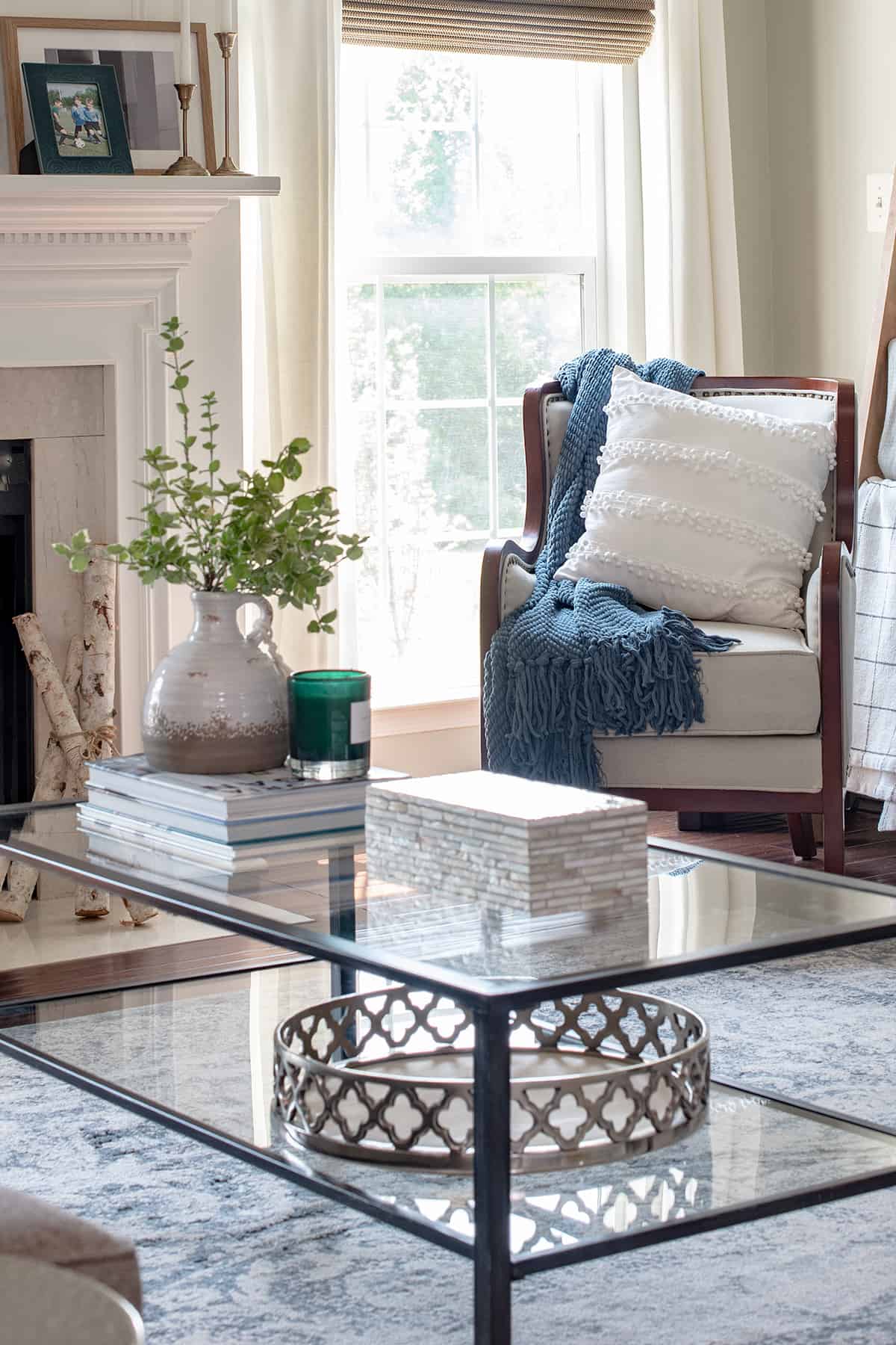 Coffee table with decor items and reading nook in front of a window.