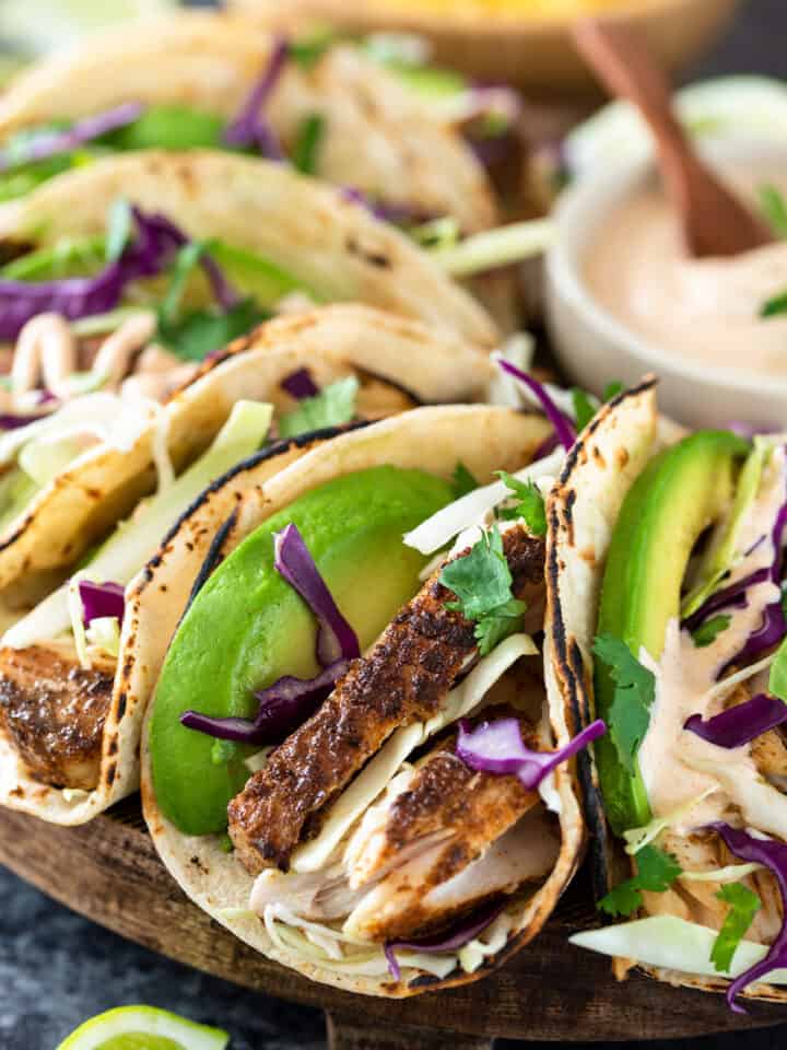 Closeup of fish tacos with avocado and cabbage slaw.
