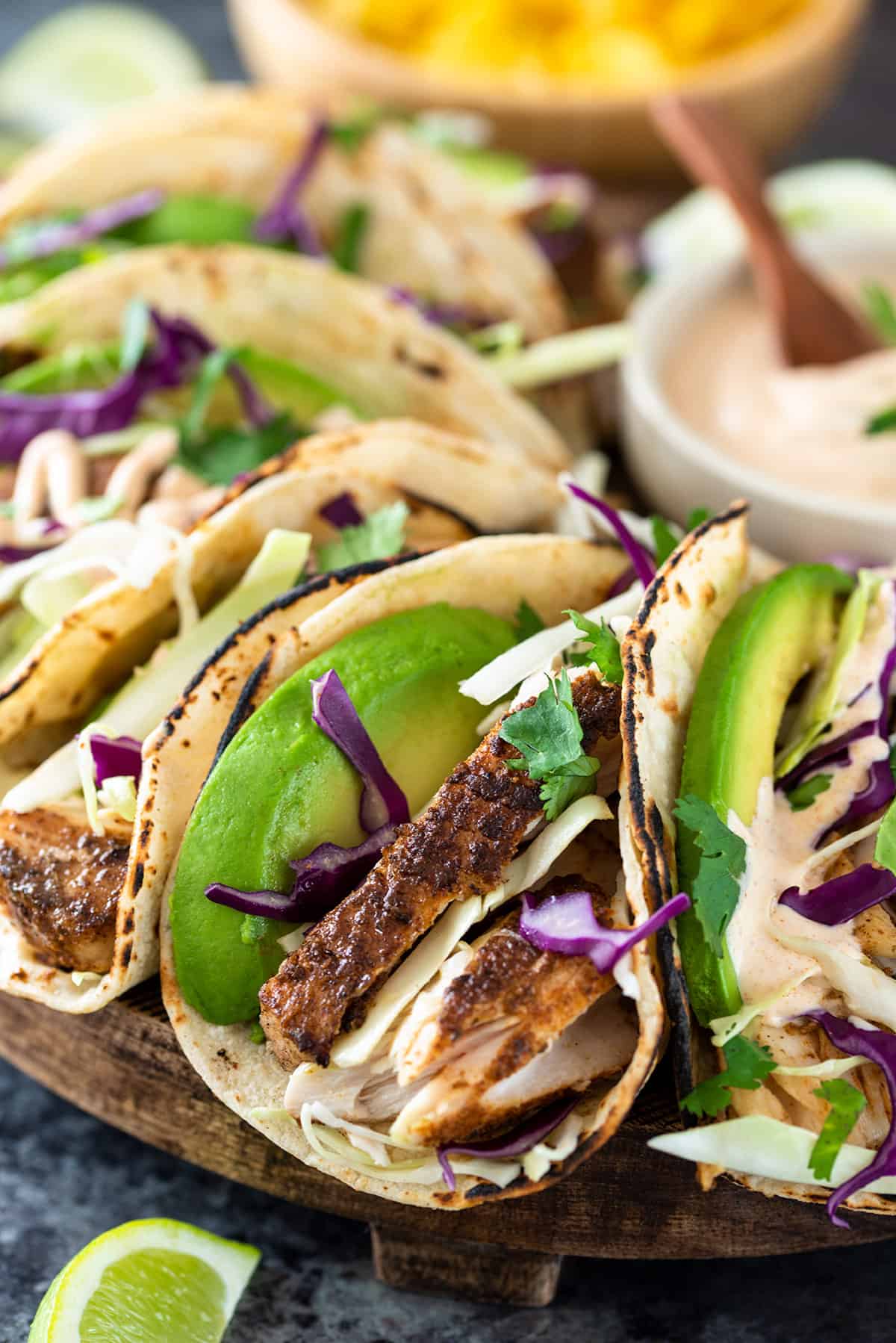 Closeup of fish tacos with avocado and cabbage slaw.