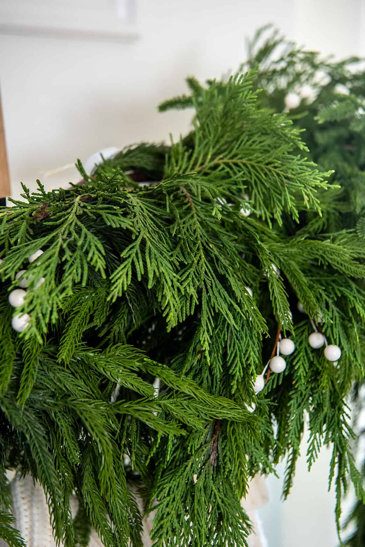 Mixed textures of greenery on a garland swag with Norfolk pine, cedar, and white berries.
