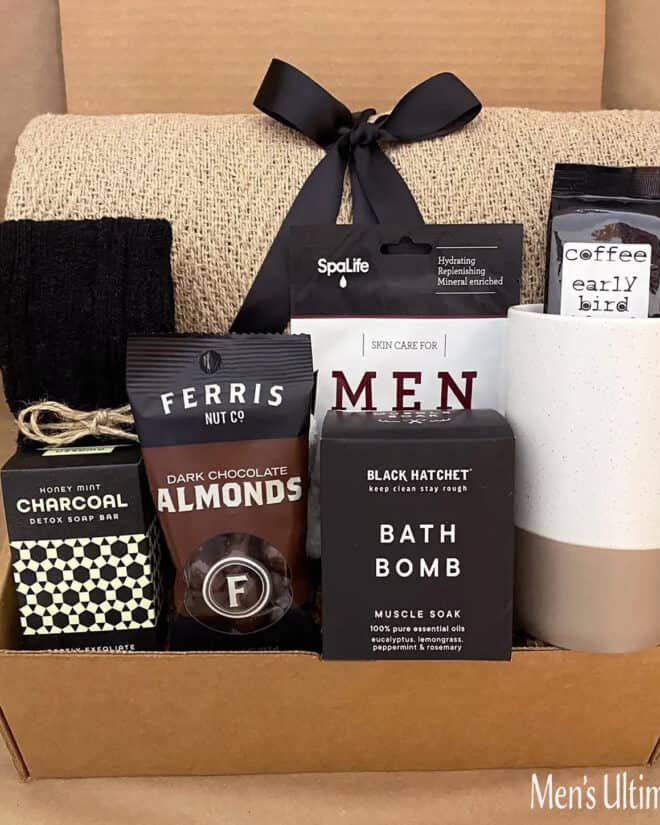 Men's Care package gift box with snacks and suds or bath items like soap and coffee mug in it.