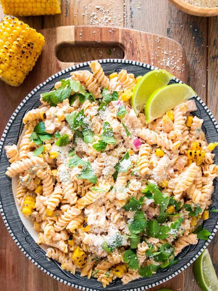 Overhead of mexican street corn pasta salad on a plate with cotija cheese sprinkled around.