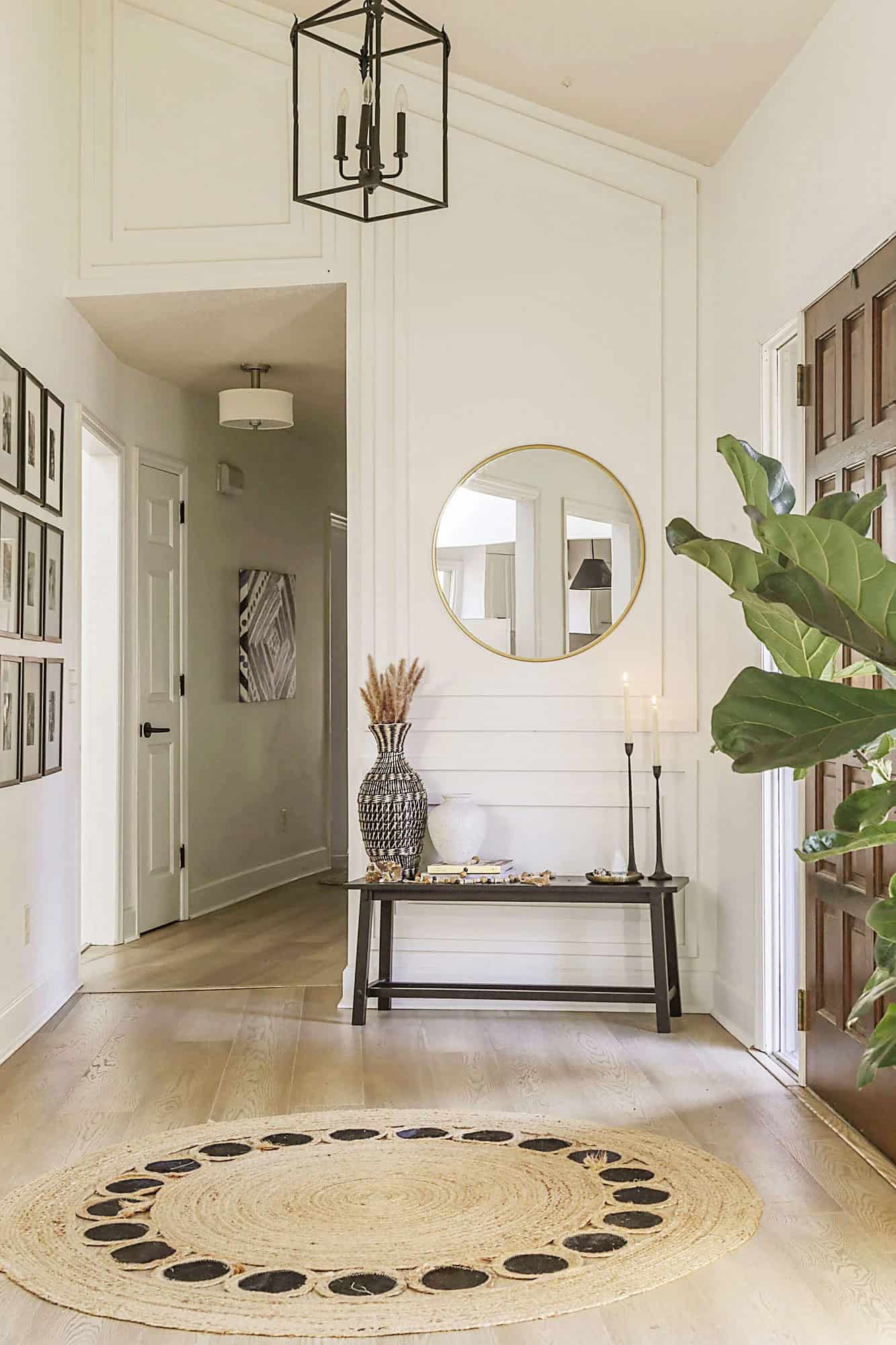 Elegant foyer with modern picture frame molding accent wall in white modern decor.