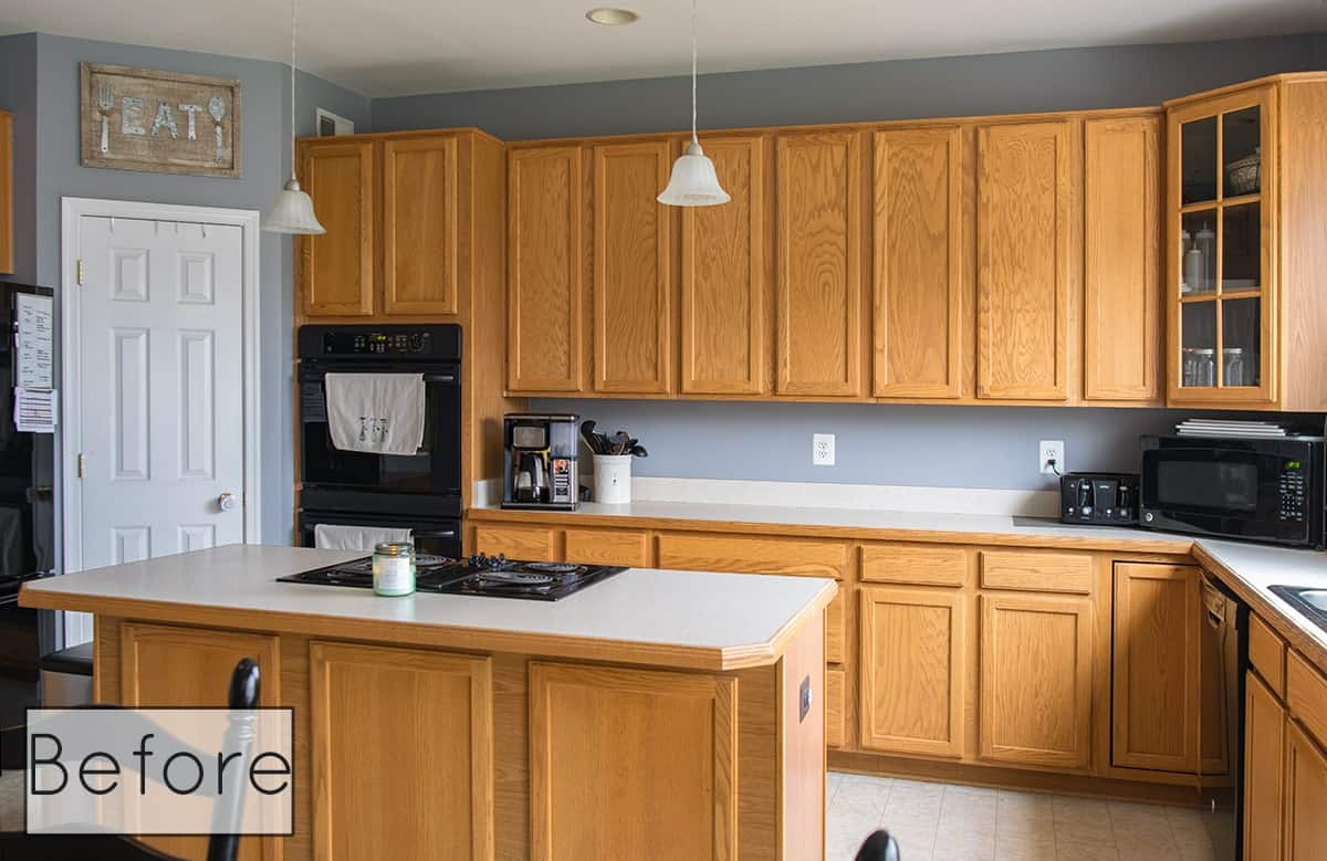 Before photo of kitchen cabinets light oak with white countertops.