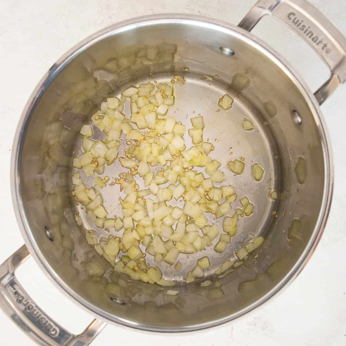 Looking into a soup pot with cooking onions and garlic.
