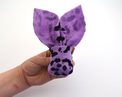 Holding a napkin folded bunny pouch up.