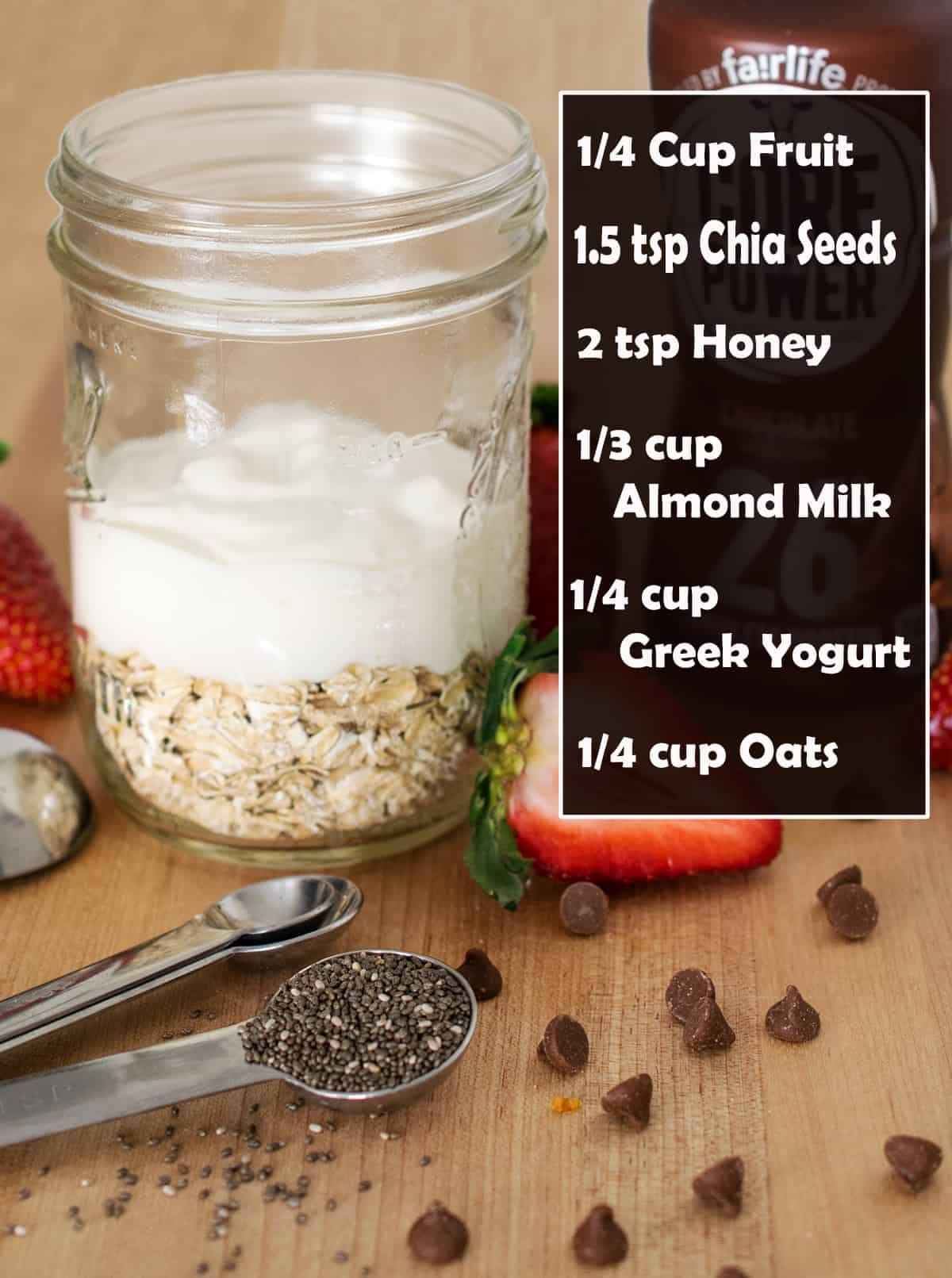 A mason jar filled with oats, greek yogurt, almond milk, chia seeds, and honey on wooden cutting board. text label of recipe.
