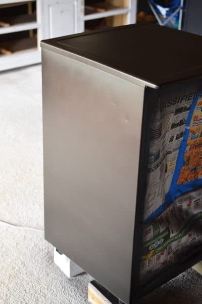 Painting a refrigerator black using black primer.