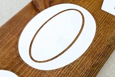 Stencil laid on top of stained wood.