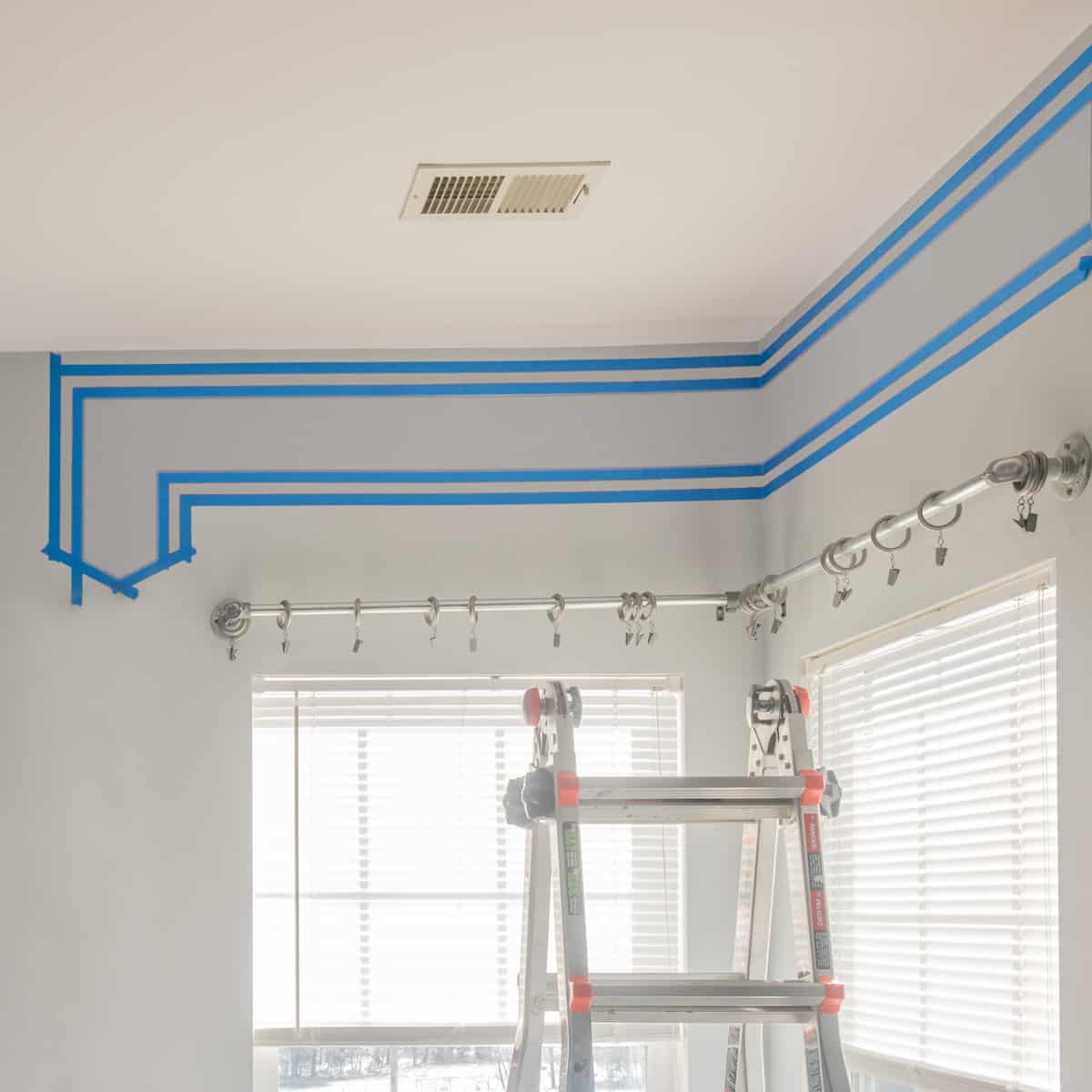 Paint's tape put on the wall to make a single horizontal stripe across the wall with arrow pointing downward.