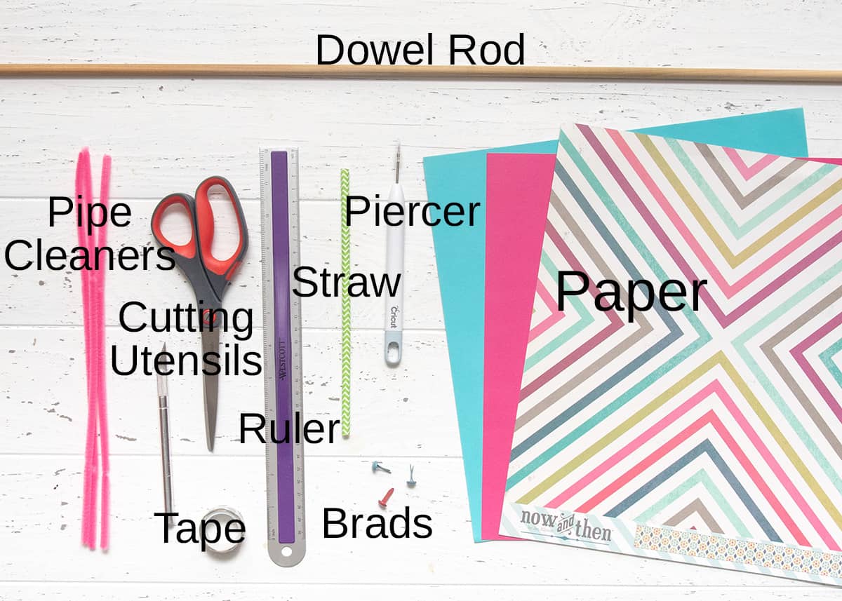 Materials needed for making DIY pinwheels-ruler, pencils, scissors, craft paper, tape, and dowel rods.