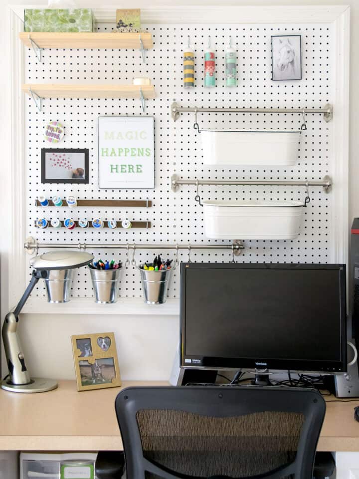 Desk area with large pegboard for craft and office supplies.