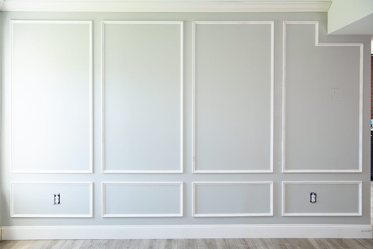 A flat wall with crown molding, picture frame molding, and baseboards.