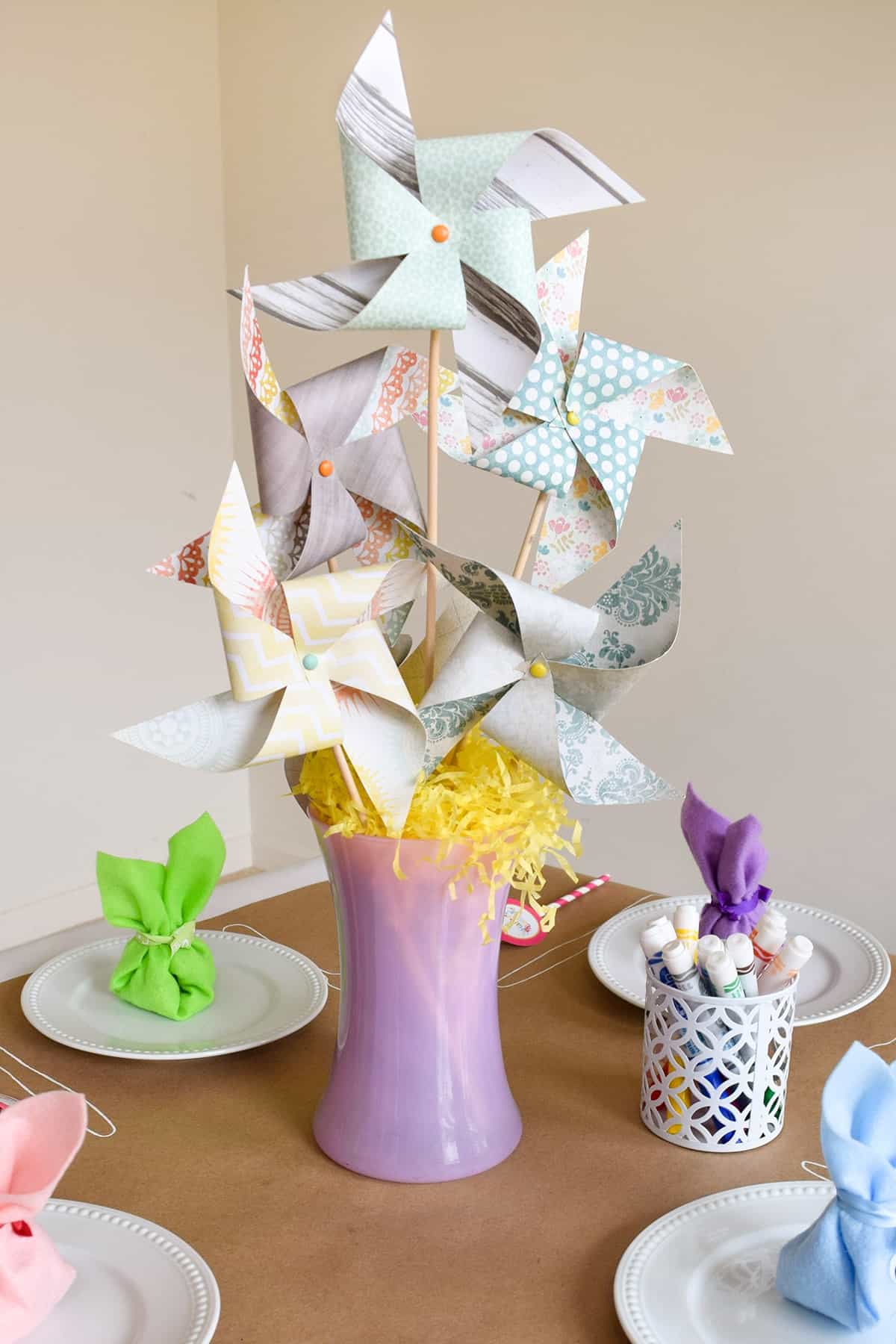 Scrapbook windmill centerpiece on a table for Easter decorations.