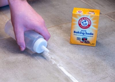 Man adding peroxide to baking soda to clean tile.