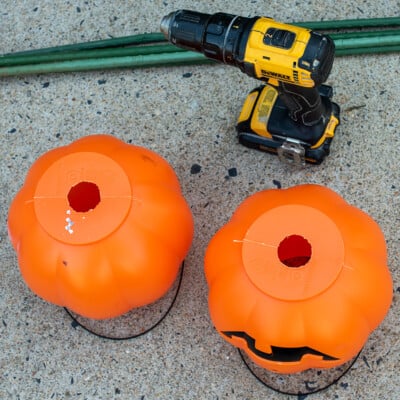 Two pumpkins with holes cut into the center of the bottom with a drill and razor knife.