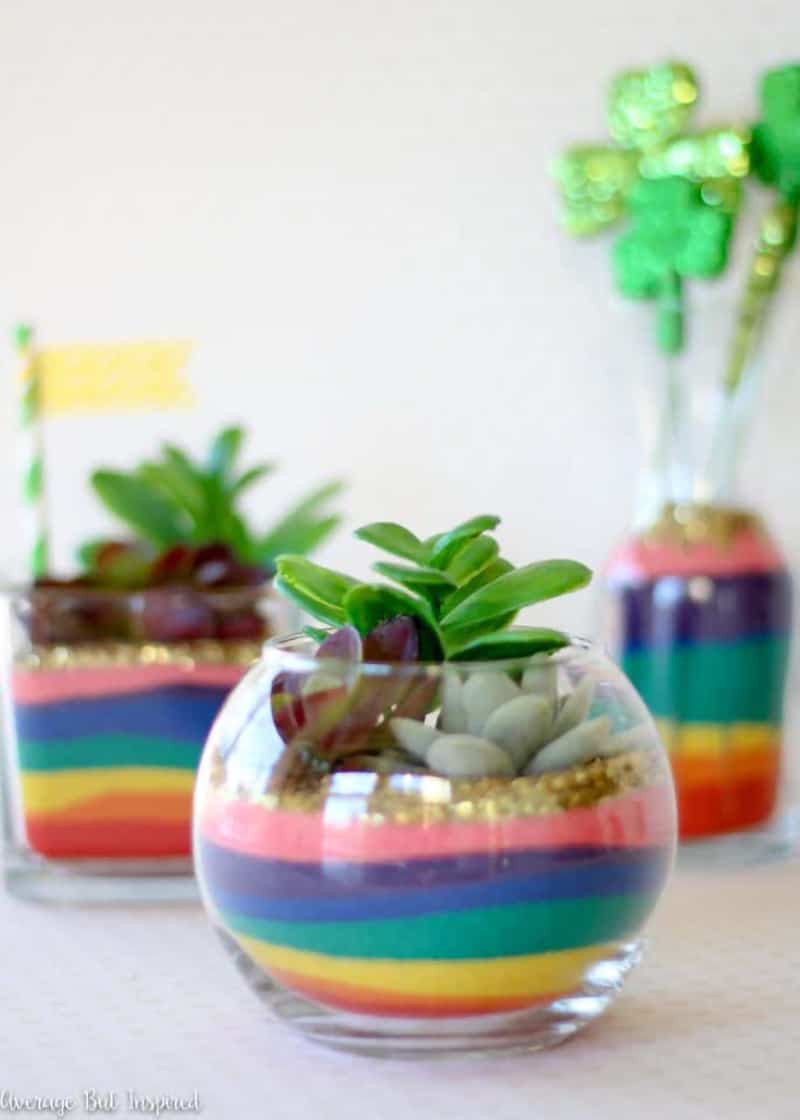 Mini rainbow sand terrariums with succulents in them.
