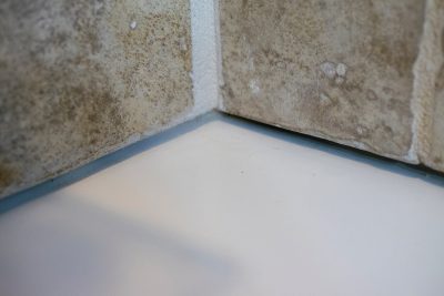 A corner of a bathtub rim with the caulk removed.