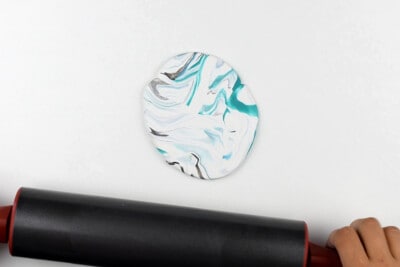 Rolling modeling clay flat with a roller.