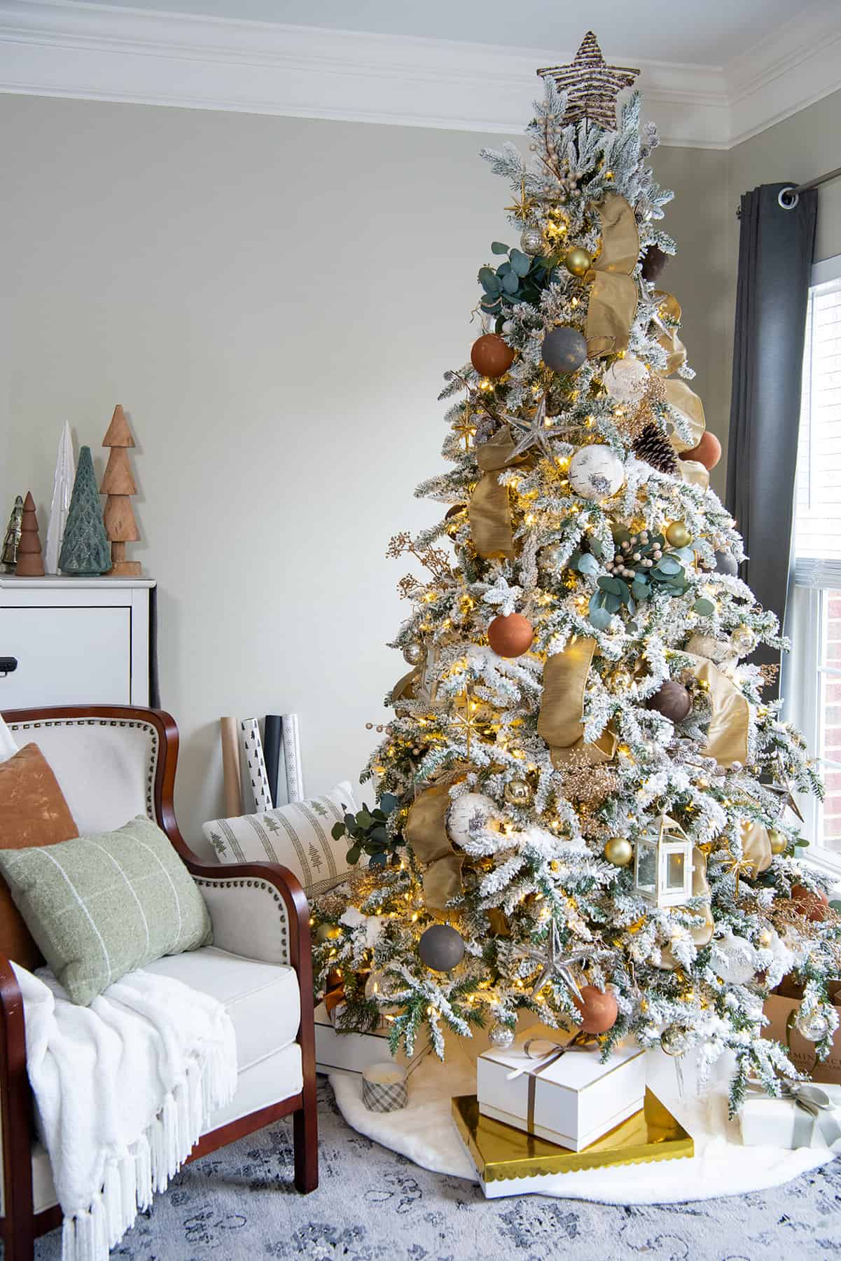 Natural Christmas tree lit up with earthy decorations.