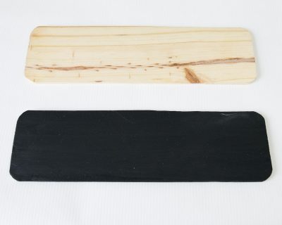 Two pieces of wood with rounded edges and one is painted black.