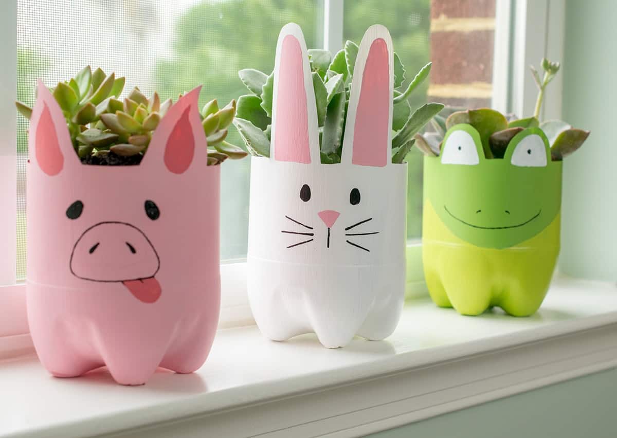 Spring plastic bottle planters with painted soda bottle animals an succulents in them.