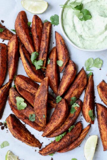 Southwestern seasoned sweet potato wedges spread out on a plate.