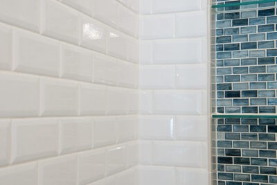 Sparkling clean white shower wall with tile niche.