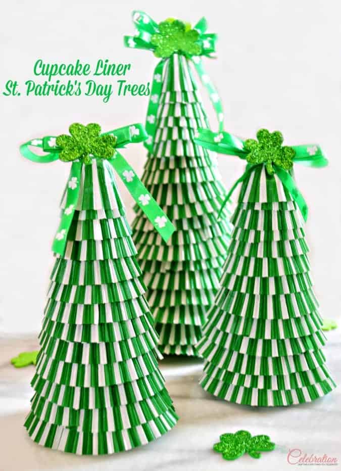 Three DIY tree crafts made of stacked green and white cupcake liners with shamrock ribbon and glittered shamrock tree toppers.