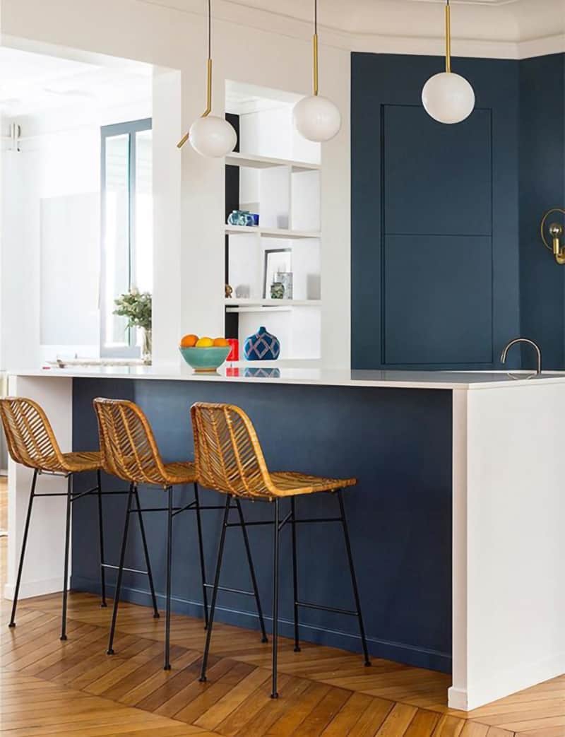 Scandinavian style kitchen features Stiffkey Blue on island and cabinets. White countertops and minimal accents with pops of color complete the look.