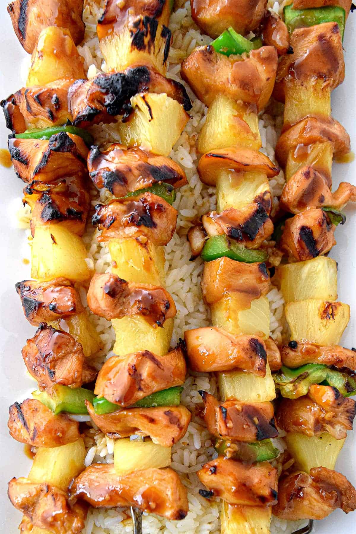 Honey Teriyaki Chicken Kabobs grilled with marinated chicken, green peppers, and pineapple over with rice.