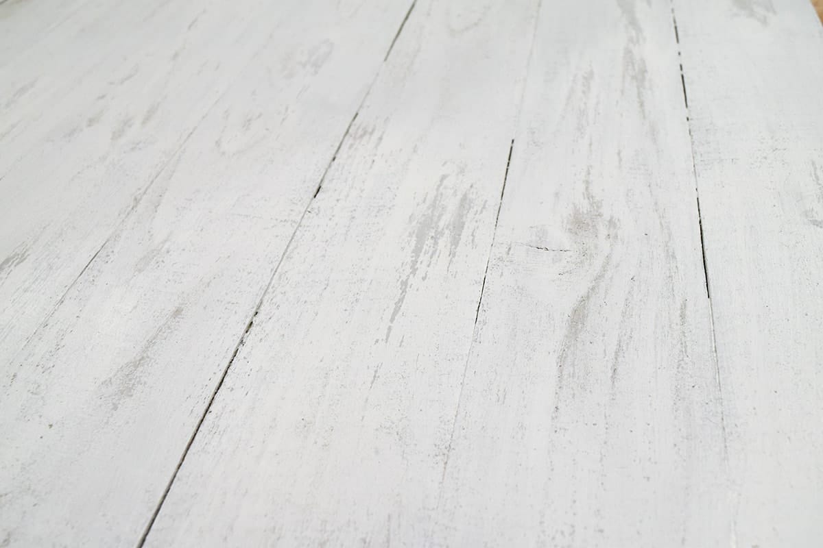 Detail of DIY sign with chalky white distressed finish.