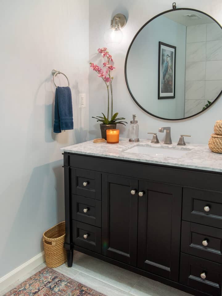 Black vanity with round mirror and bohemian decor.