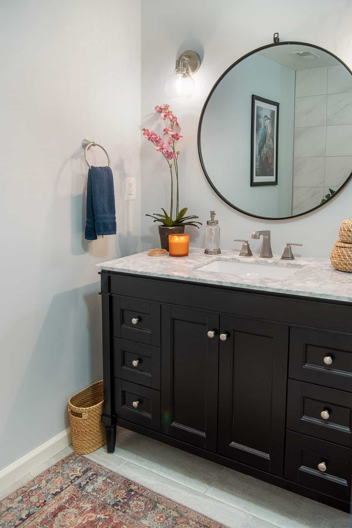 Black vanity with round mirror and bohemian decor.