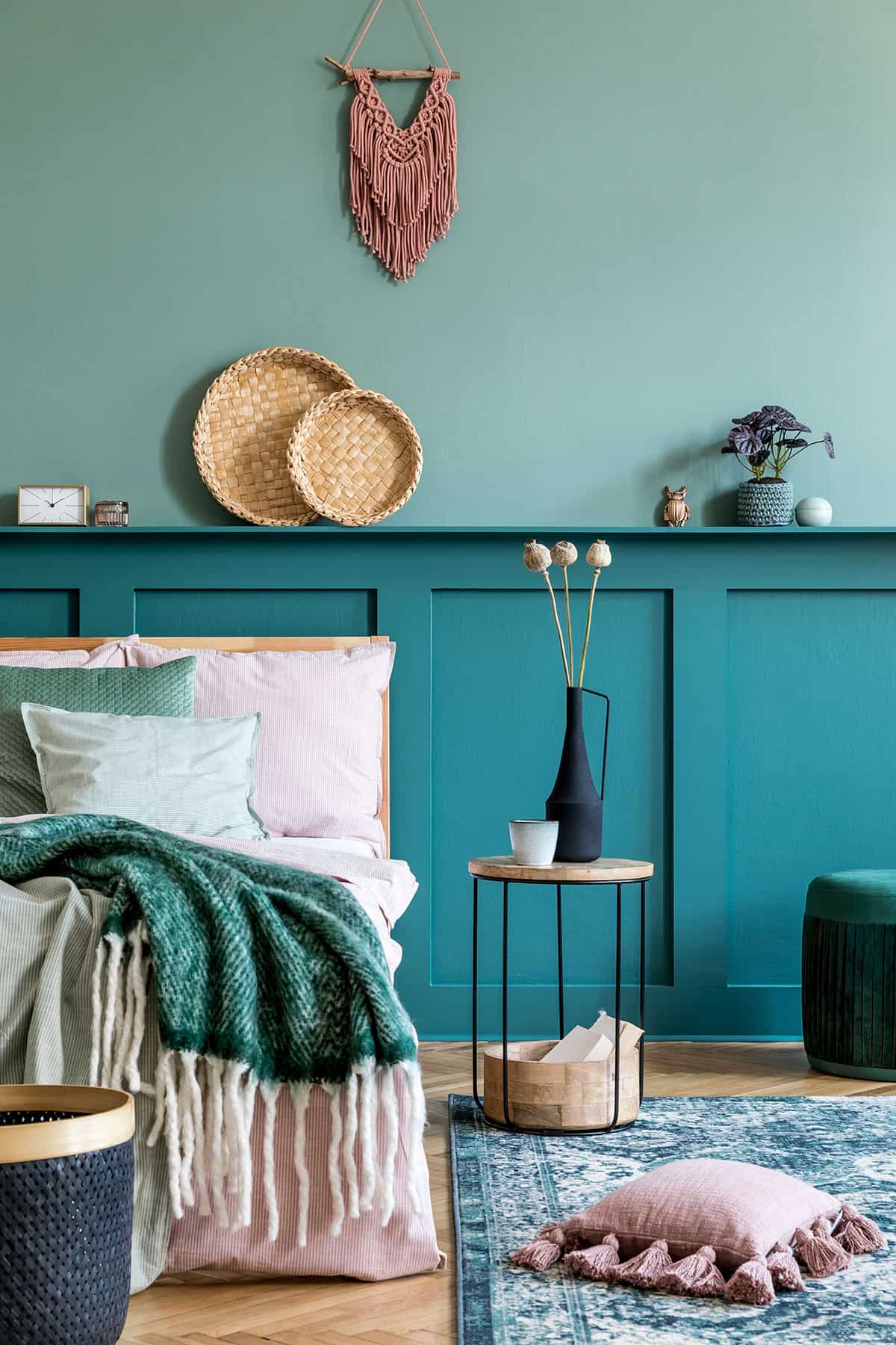 Two-tone feature wall in bold shades of teal board and batten in a boho bedroom.