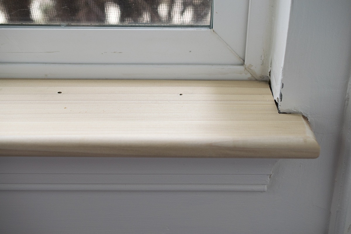 New window sill with nail holes around the edges.