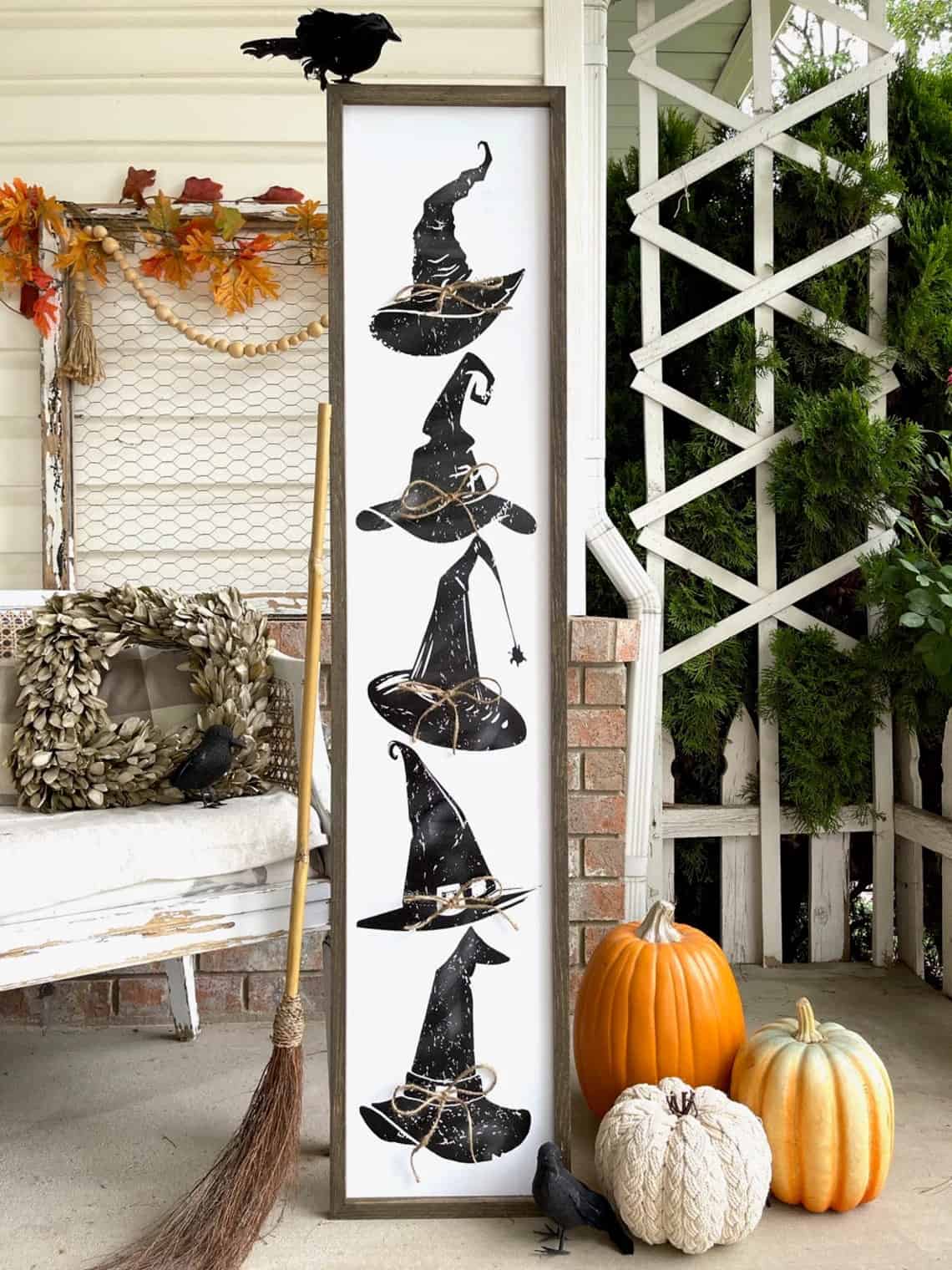 Porch sign with witch hats on it for a Halloween porch decoration.
