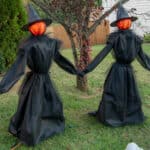 Two witches holding hands yard decoration for halloween.