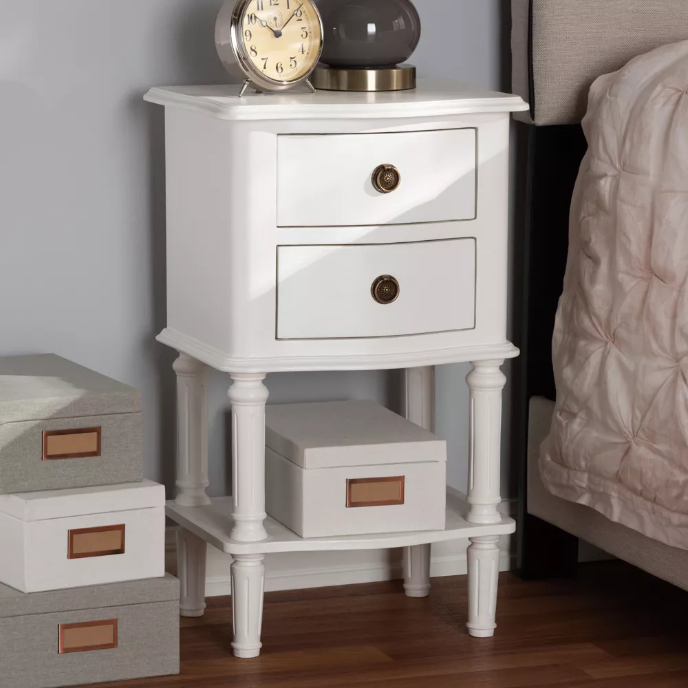 White cottage style 2-drawer nightstand with gentle curves, stilted legs, and brass hardware.